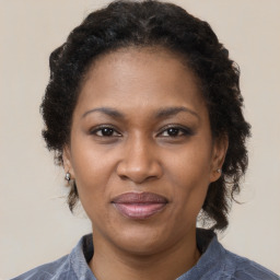 Joyful black adult female with medium  brown hair and brown eyes