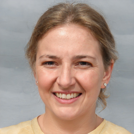 Joyful white adult female with medium  brown hair and brown eyes