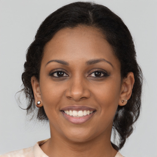 Joyful black young-adult female with long  brown hair and brown eyes