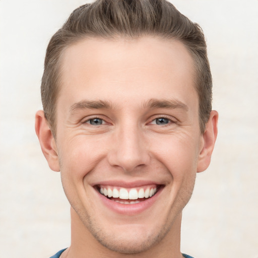 Joyful white young-adult male with short  brown hair and grey eyes