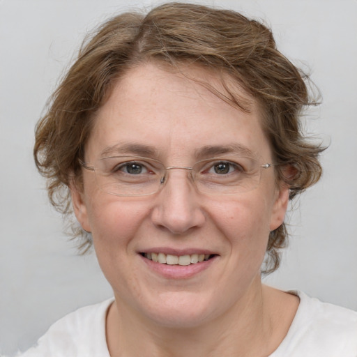 Joyful white adult female with medium  brown hair and green eyes