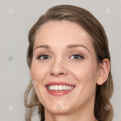 Joyful white young-adult female with medium  brown hair and blue eyes