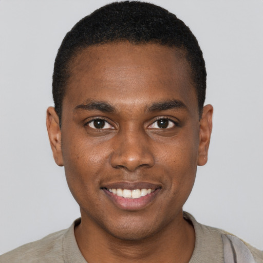 Joyful black young-adult male with short  black hair and brown eyes