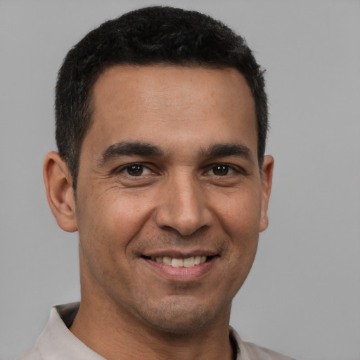Joyful white young-adult male with short  black hair and brown eyes