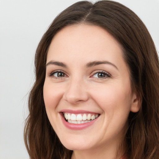 Joyful white young-adult female with long  brown hair and green eyes