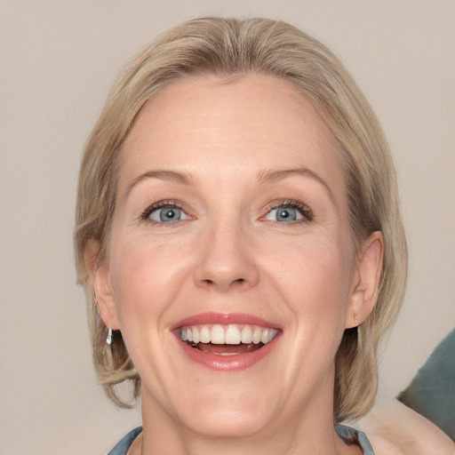 Joyful white adult female with medium  brown hair and blue eyes