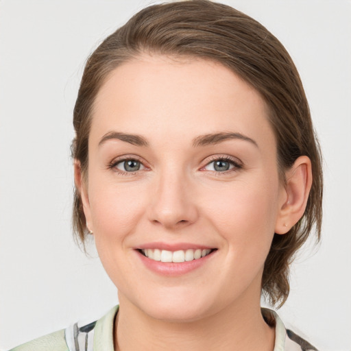 Joyful white young-adult female with medium  brown hair and grey eyes