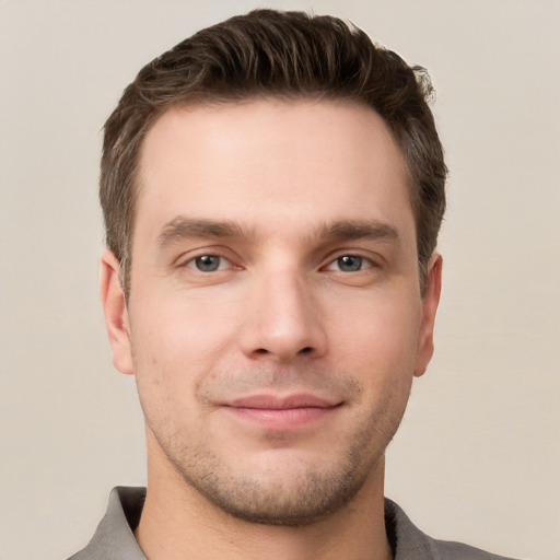 Joyful white young-adult male with short  brown hair and grey eyes