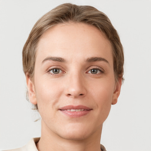 Joyful white young-adult female with short  brown hair and grey eyes