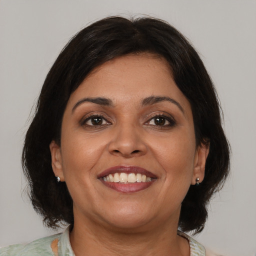 Joyful latino adult female with medium  brown hair and brown eyes