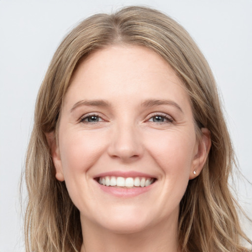 Joyful white young-adult female with long  brown hair and grey eyes