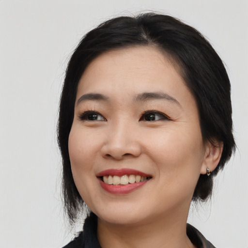 Joyful asian young-adult female with medium  black hair and brown eyes