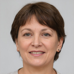 Joyful white adult female with medium  brown hair and grey eyes