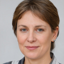 Joyful white adult female with medium  brown hair and grey eyes