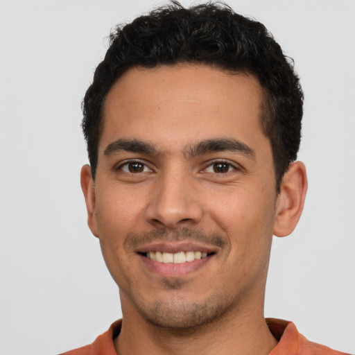 Joyful latino young-adult male with short  brown hair and brown eyes