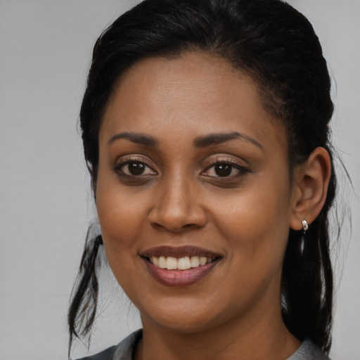 Joyful black young-adult female with long  black hair and brown eyes