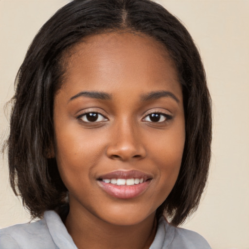 Joyful black young-adult female with medium  brown hair and brown eyes