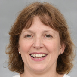 Joyful white adult female with medium  brown hair and blue eyes