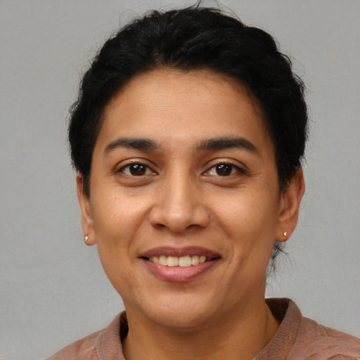 Joyful latino young-adult female with short  black hair and brown eyes
