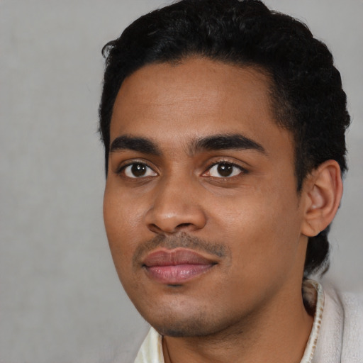Joyful black young-adult male with short  black hair and brown eyes