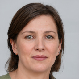 Joyful white adult female with medium  brown hair and grey eyes