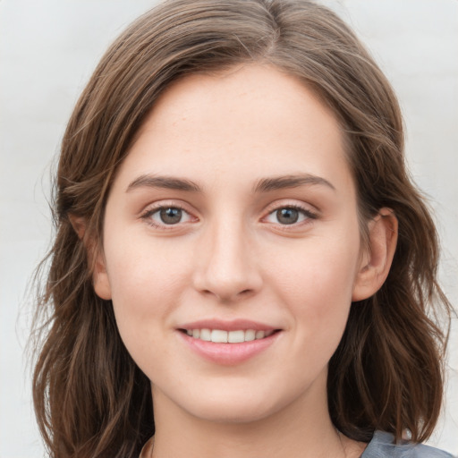 Joyful white young-adult female with long  brown hair and grey eyes