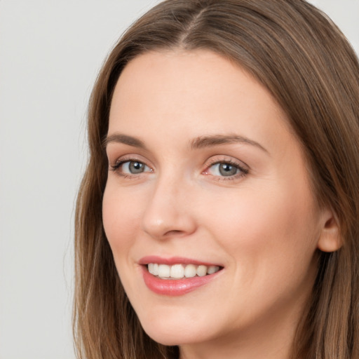 Joyful white young-adult female with long  brown hair and grey eyes