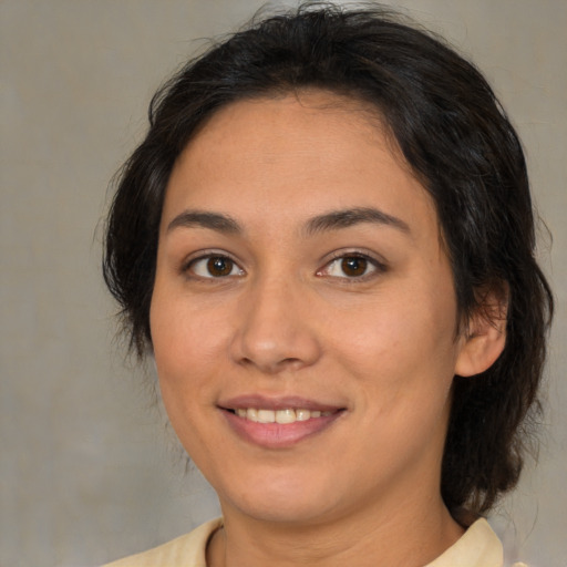 Joyful latino young-adult female with medium  brown hair and brown eyes