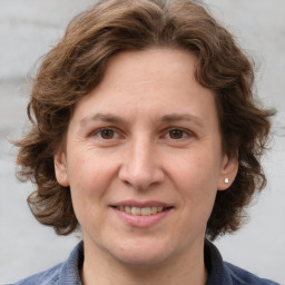 Joyful white adult female with medium  brown hair and grey eyes