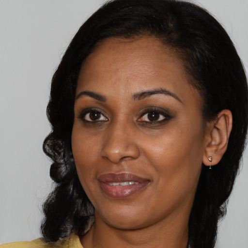 Joyful black young-adult female with medium  black hair and brown eyes