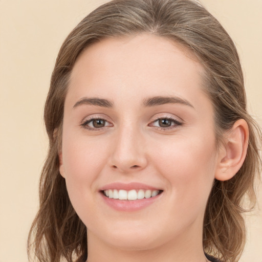 Joyful white young-adult female with long  brown hair and grey eyes