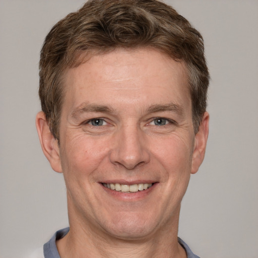 Joyful white adult male with short  brown hair and grey eyes