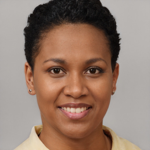 Joyful black young-adult female with short  brown hair and brown eyes