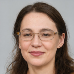 Joyful white adult female with long  brown hair and grey eyes