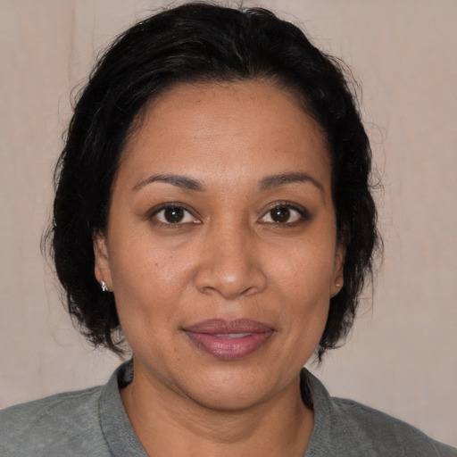 Joyful latino adult female with medium  brown hair and brown eyes