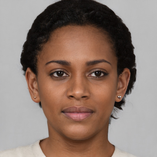 Joyful black young-adult female with short  black hair and brown eyes