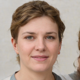 Joyful white young-adult female with medium  brown hair and grey eyes