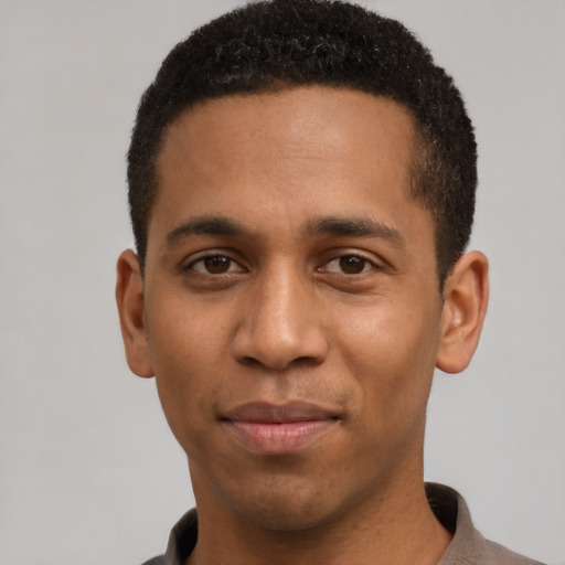 Joyful black young-adult male with short  black hair and brown eyes