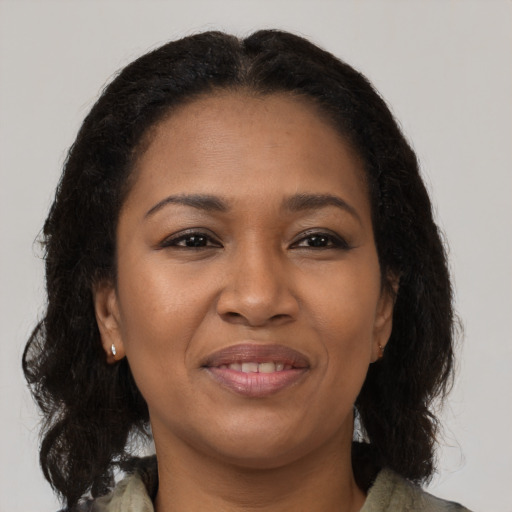 Joyful black young-adult female with long  brown hair and brown eyes