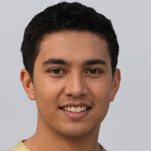 Joyful latino young-adult male with short  brown hair and brown eyes