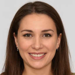 Joyful white young-adult female with long  brown hair and brown eyes