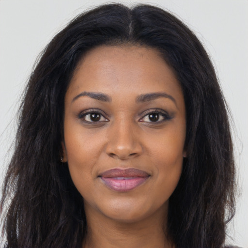 Joyful black young-adult female with long  brown hair and brown eyes