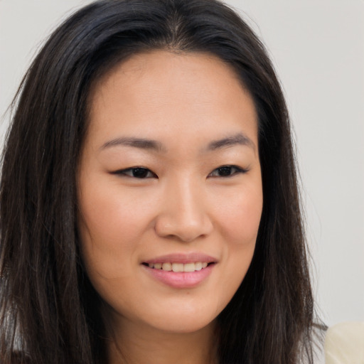 Joyful asian young-adult female with long  brown hair and brown eyes