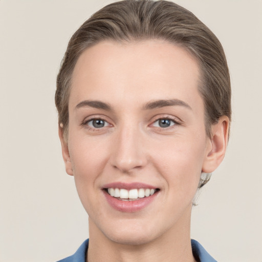 Joyful white young-adult female with short  brown hair and grey eyes