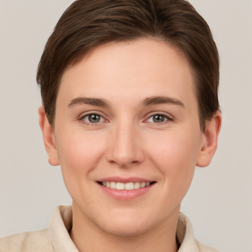 Joyful white young-adult female with short  brown hair and grey eyes