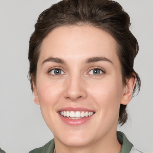 Joyful white young-adult female with medium  brown hair and green eyes