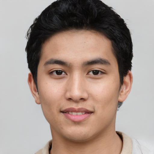 Joyful asian young-adult male with short  black hair and brown eyes