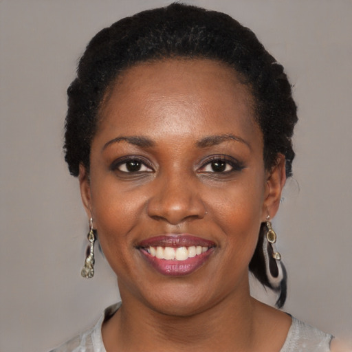 Joyful black young-adult female with short  black hair and brown eyes