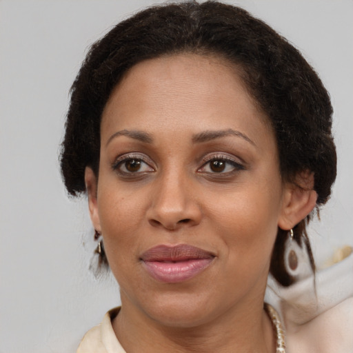 Joyful black adult female with medium  brown hair and brown eyes