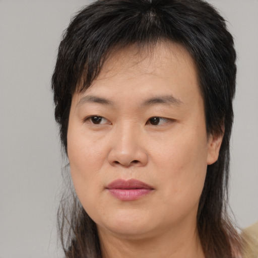 Joyful asian adult female with medium  brown hair and brown eyes